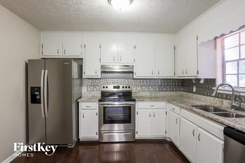 a kitchen with white cabinets and stainless steel appliances
