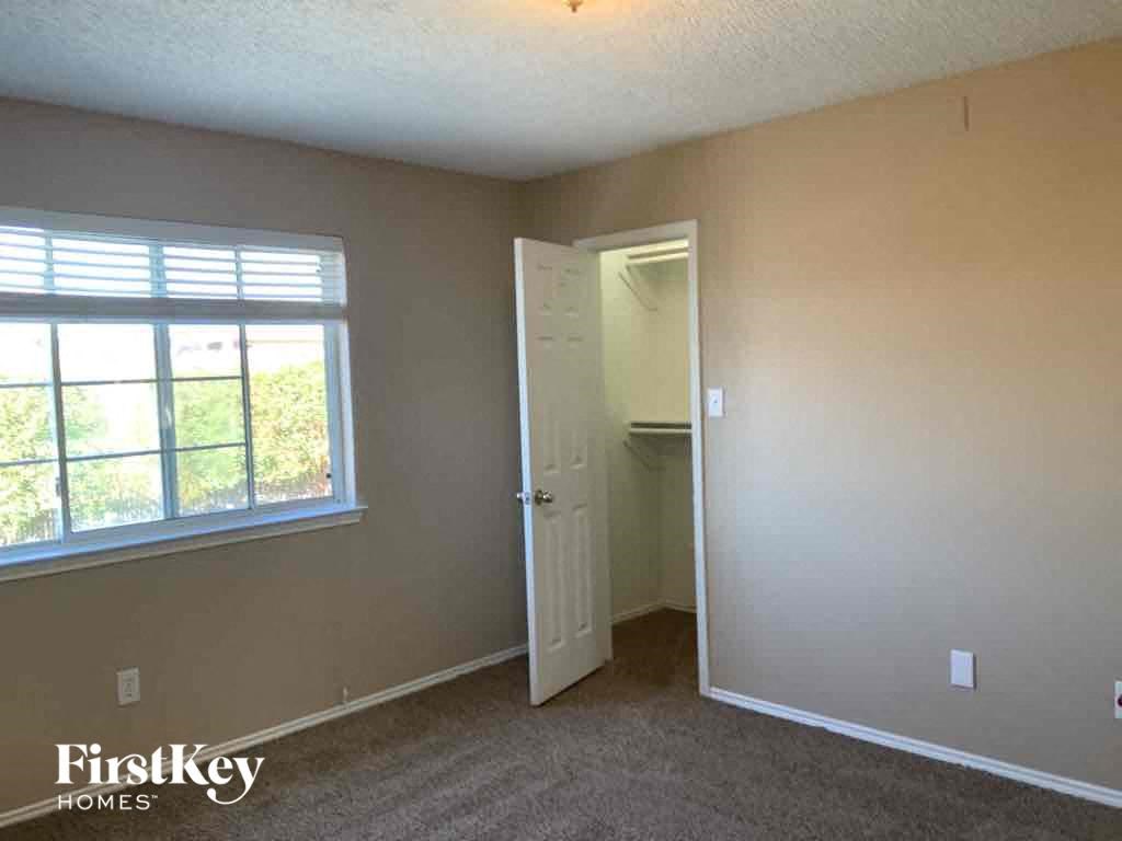 an empty bedroom with a door to a closet and a window