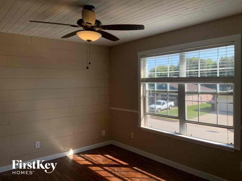 a living room with a ceiling fan and a large window
