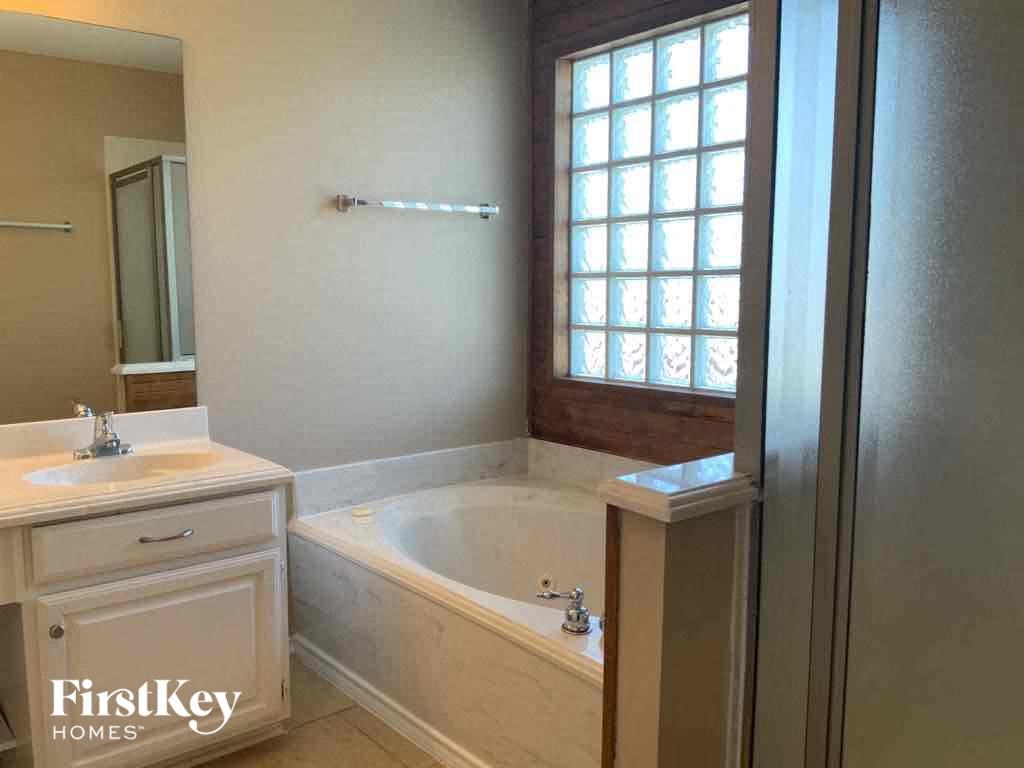 a bathroom with a tub and a sink and a mirror