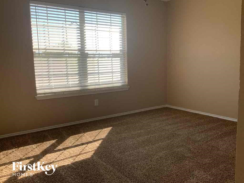 an empty room with carpet and a window