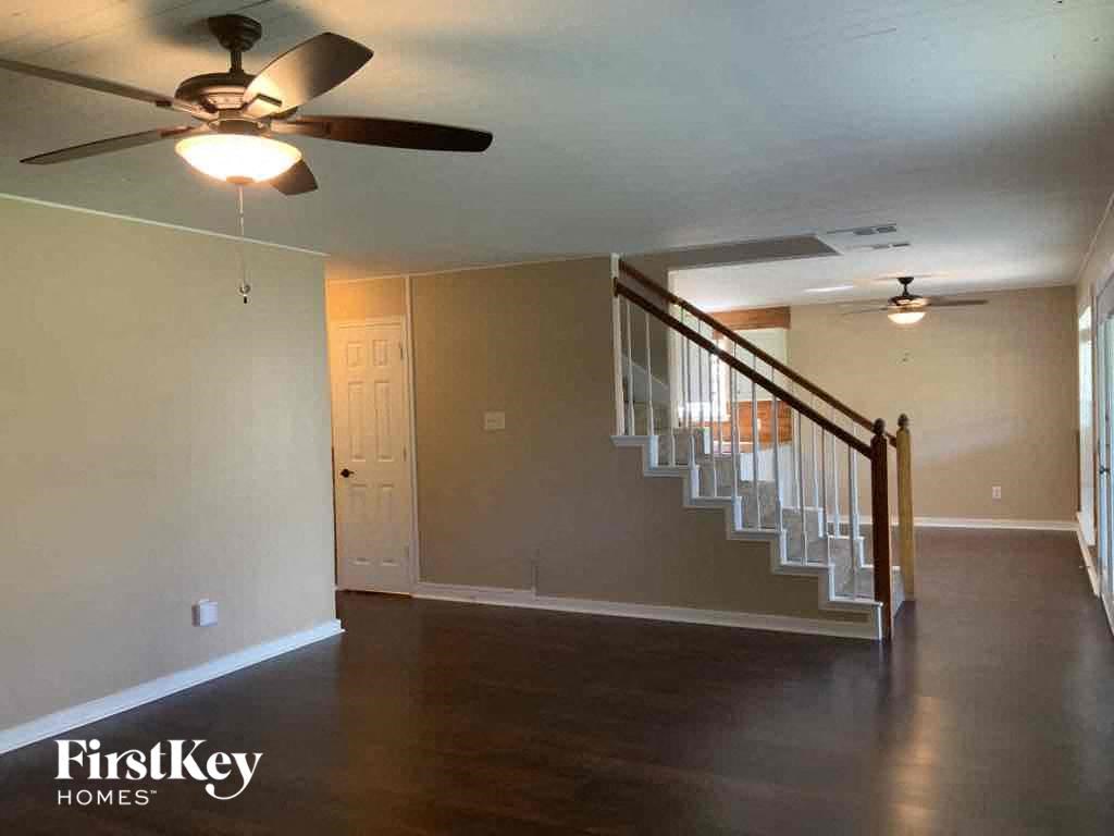 a living room with a staircase and a ceiling fan