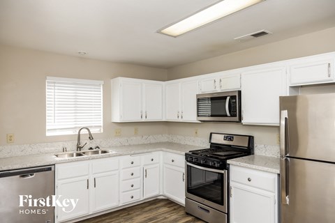 a kitchen with white cabinets and stainless steel appliances