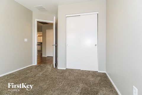 a bedroom with a closet and a door to a hallway