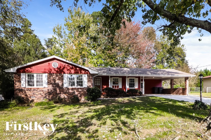 A red brick house with a white trim and a porch.