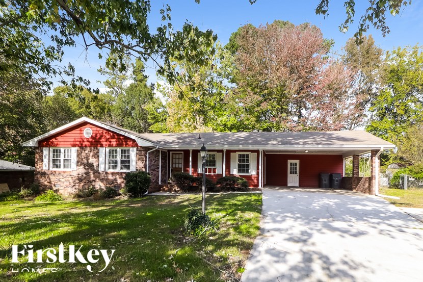 A red brick house with a white garage door and a sign that says "FirstKey Homes".