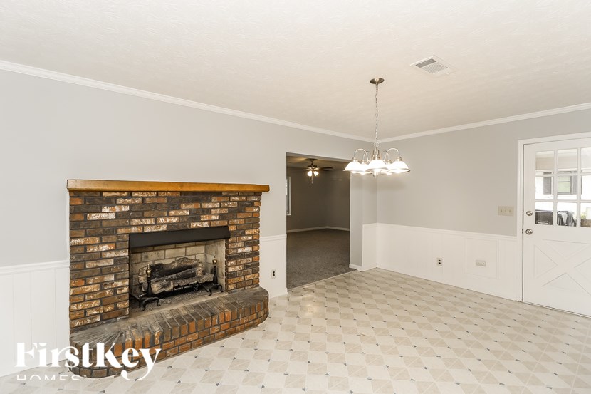 A room with a fireplace and a chandelier.