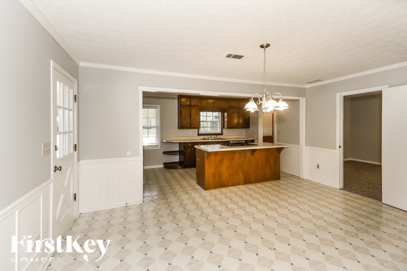 A spacious kitchen with a checkered floor and a wooden island.