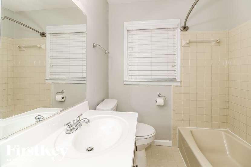 A white bathroom with a tub, toilet, and sink.