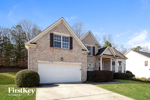 a brick house with a white garage door in front of it