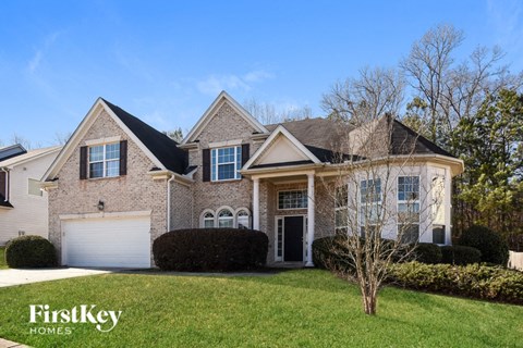 a large brick house with a lawn in front of it