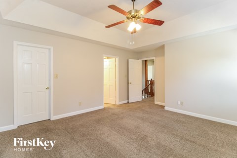 a living room with carpet and a ceiling fan
