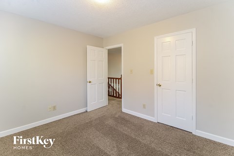 a bedroom with two doors and a carpeted floor