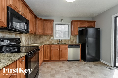 A kitchen with brown cabinets and black appliances.