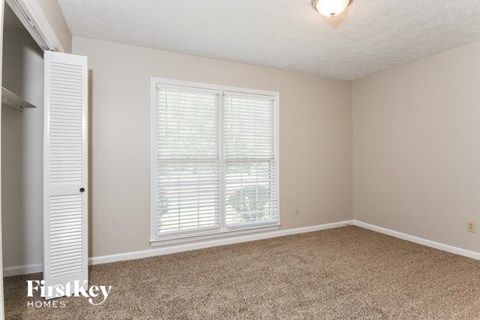 a bedroom with a large window and a white closet