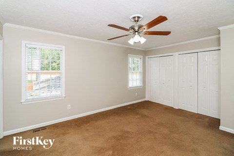 a bedroom with carpet and a ceiling fan