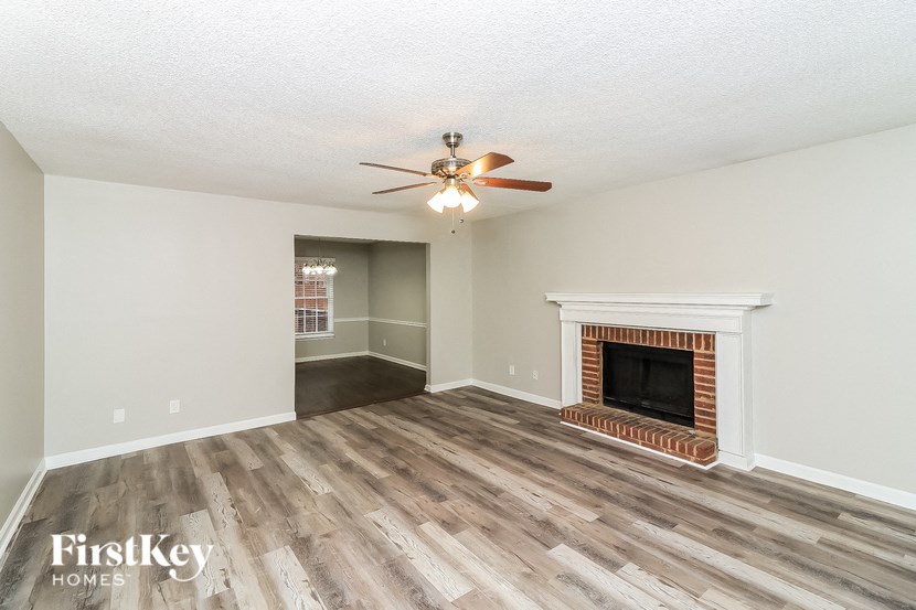 a living room with a fireplace and a ceiling fan