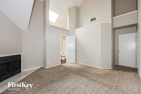 A spacious room with a skylight and a carpeted floor.