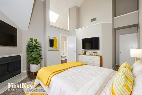A bedroom with a bed covered in a yellow blanket.