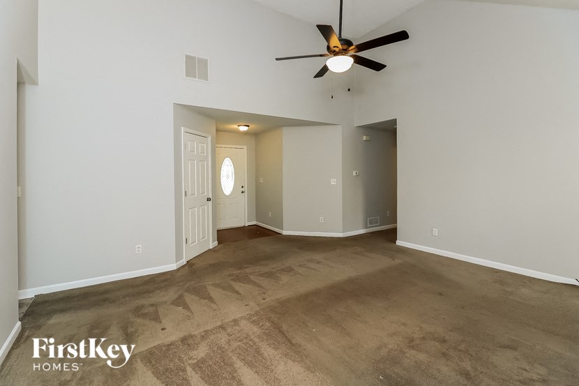 a empty living room with a ceiling fan