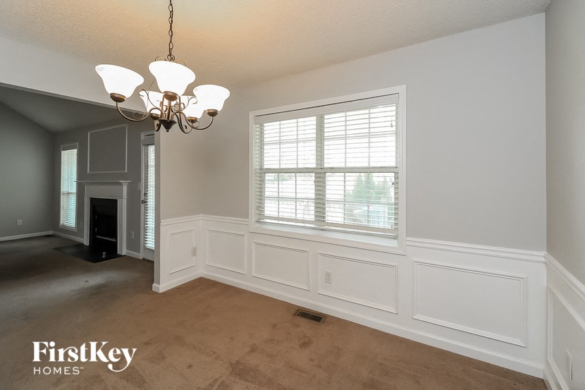 an empty living room with white walls and a window