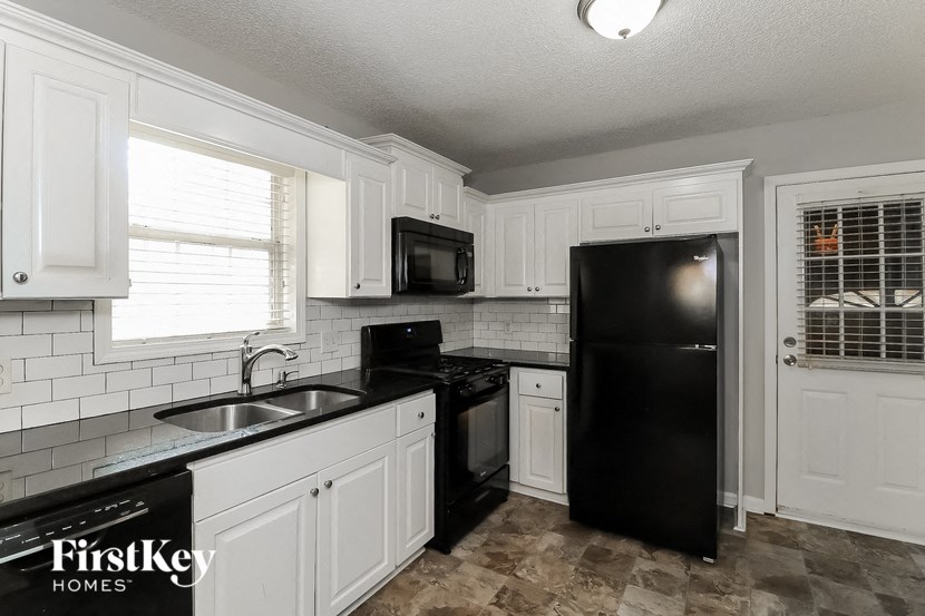 a kitchen with a black refrigerator and a sink