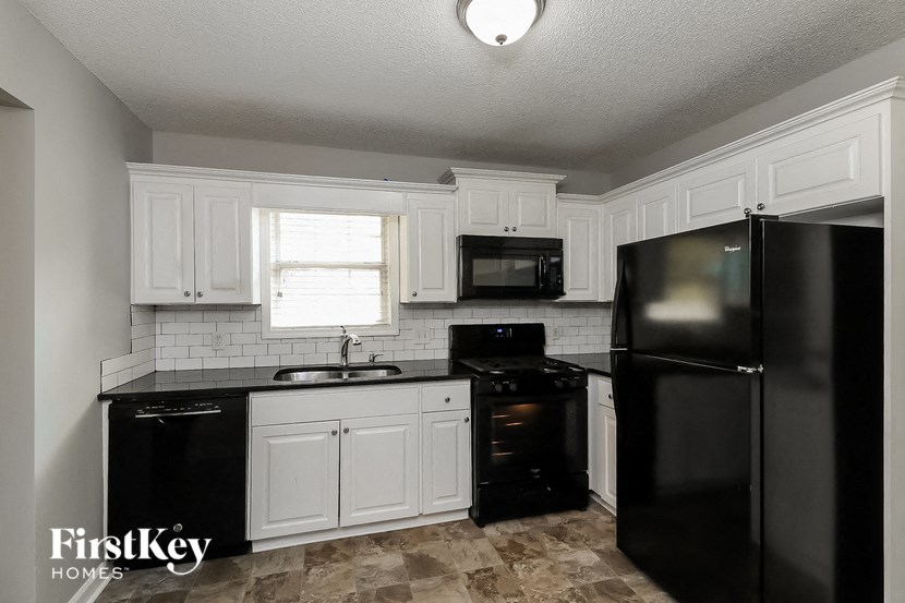 a kitchen with black appliances and white cabinets