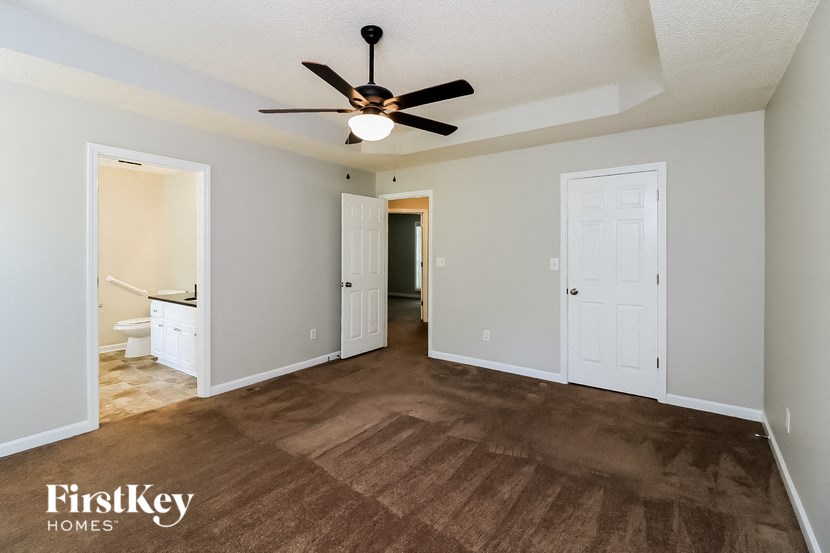 a living room with carpet and a ceiling fan