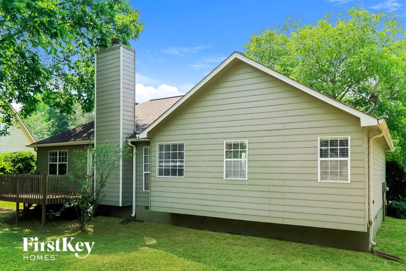 the front of a house with a deck and a tree