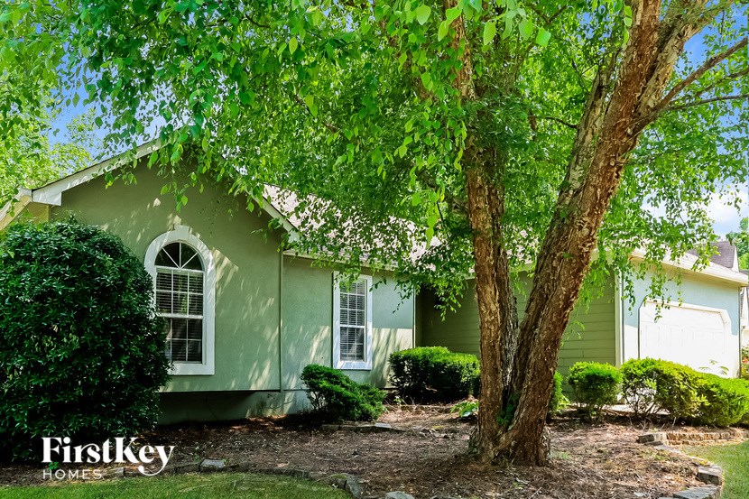 a green house with a tree in front of it