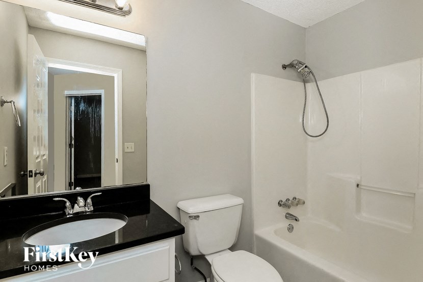 a white bathroom with a sink toilet and a shower