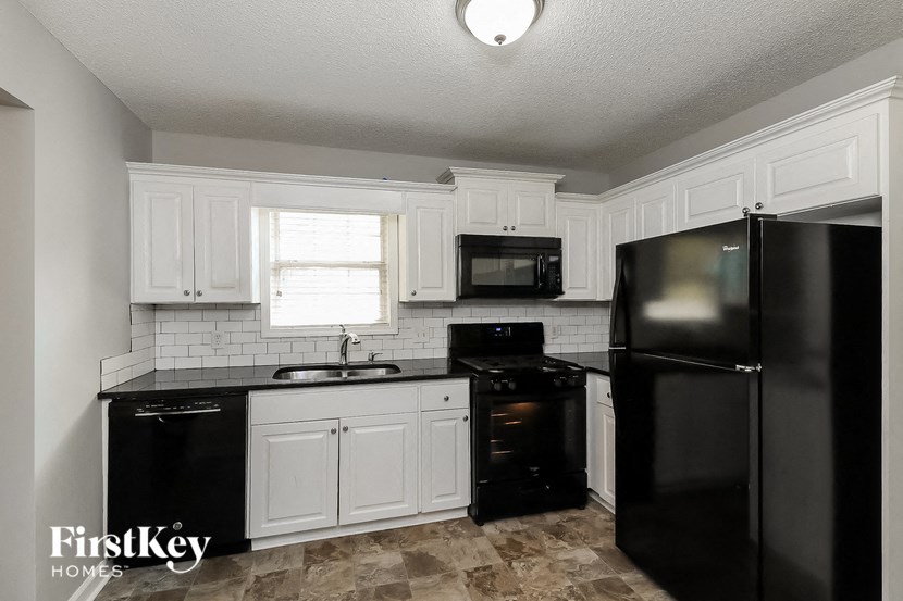 a kitchen with black appliances and white cabinets