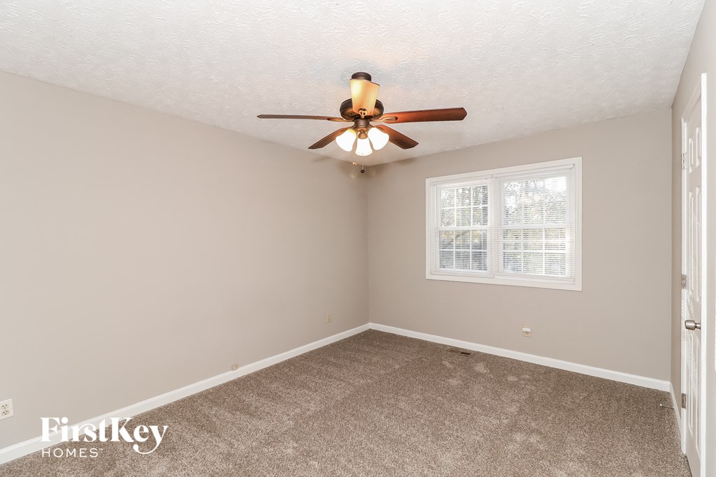 A room with a ceiling fan and a window.