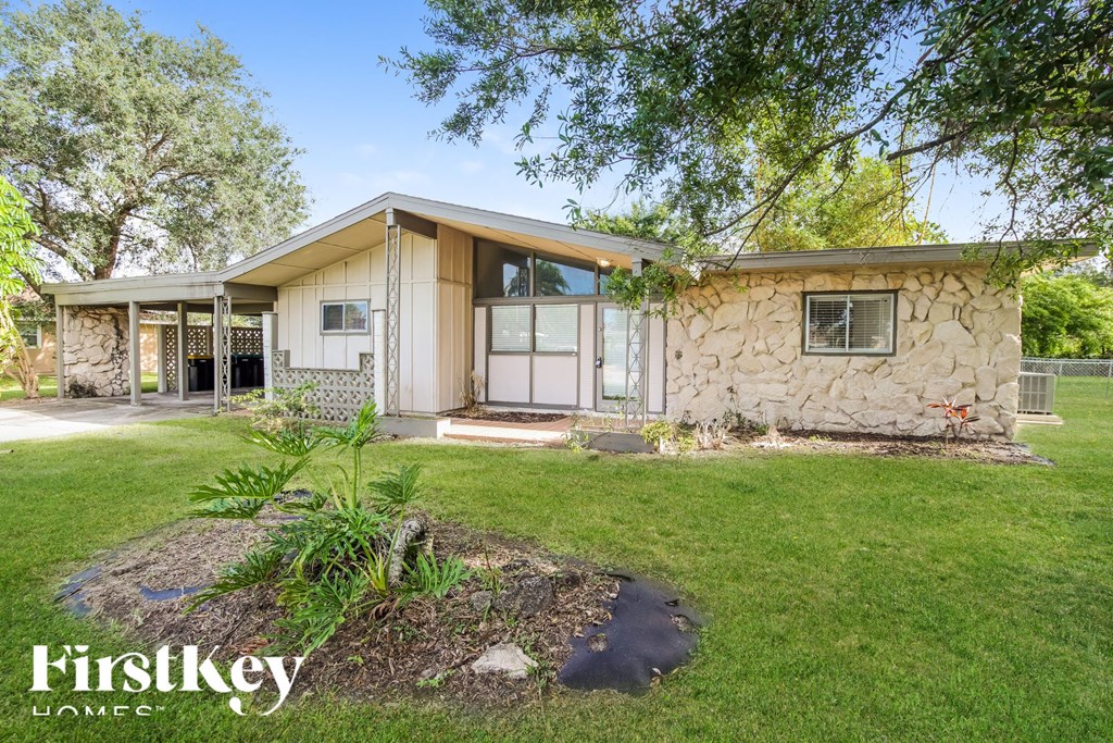 a stone house with a lawn and trees
