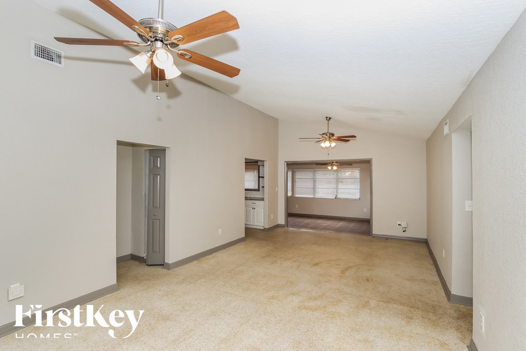a living room with a ceiling fan and two ceiling fans