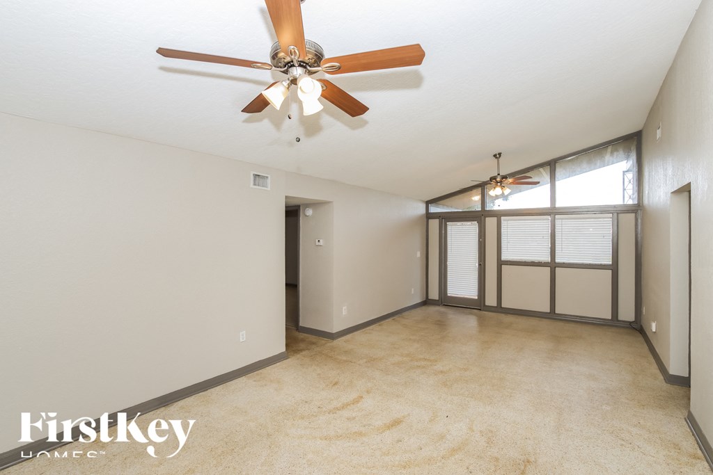 a living room with a ceiling fan and a large window