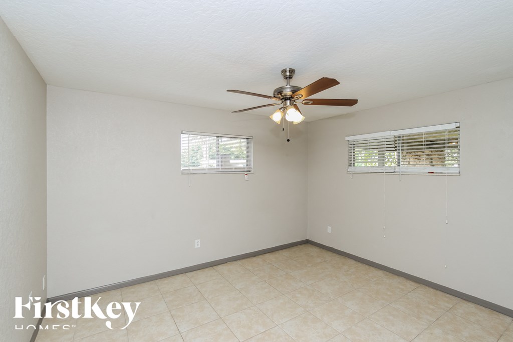a living room with a ceiling fan and a tiled floor