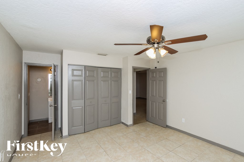 a living room with a ceiling fan and a door to a hallway