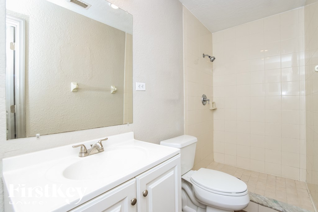 a bathroom with a sink toilet and a mirror