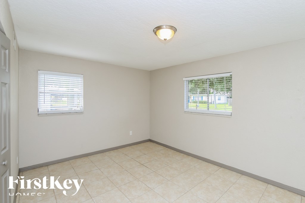 a room with a tiled floor and two windows