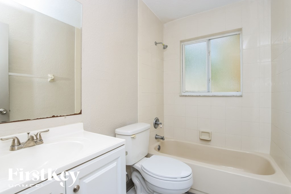 a white bathroom with a tub and a toilet and a sink
