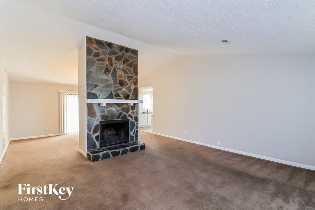 a living room with a fireplace and a carpeted floor