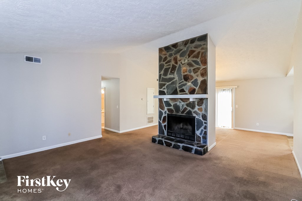 a living room with a fireplace and a carpeted floor