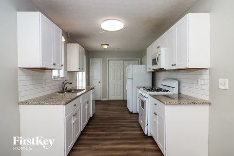 A kitchen with white cabinets and appliances.