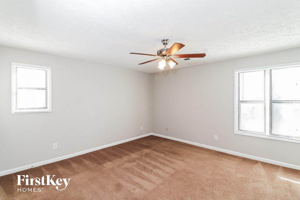 a bedroom with a ceiling fan and a wood floor
