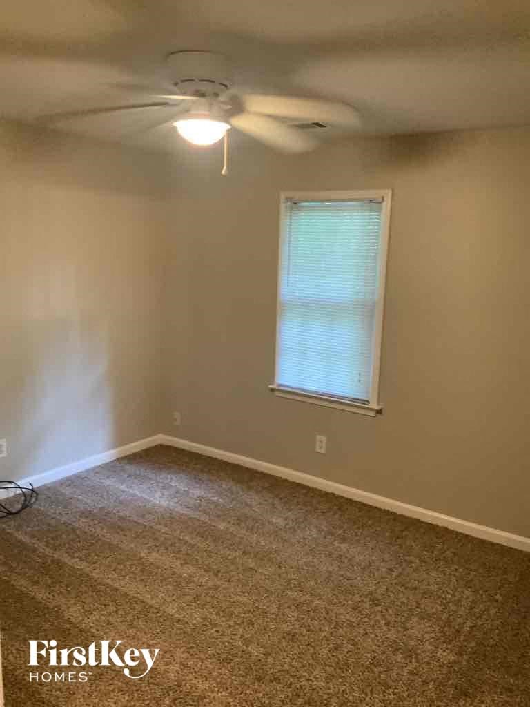 an empty room with a ceiling fan and a window