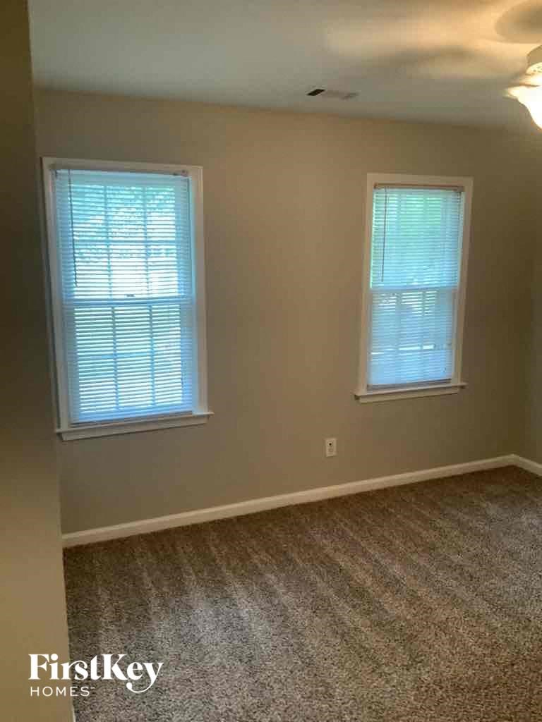 a room with a carpet and two windows