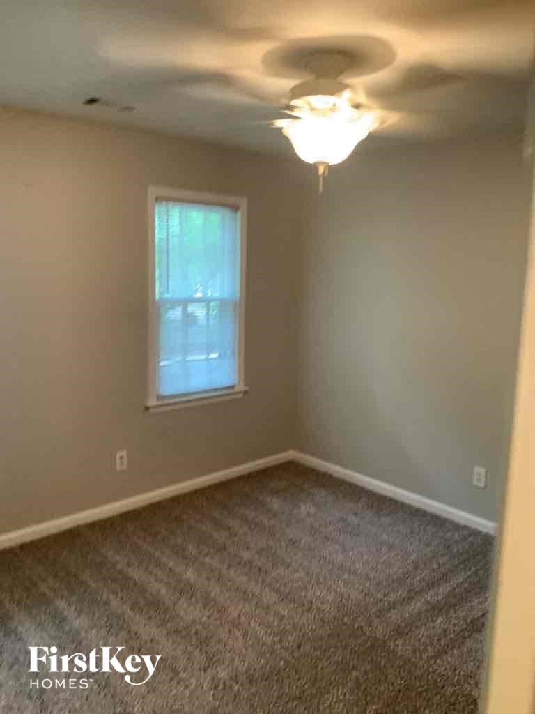 a empty room with a ceiling fan and a window