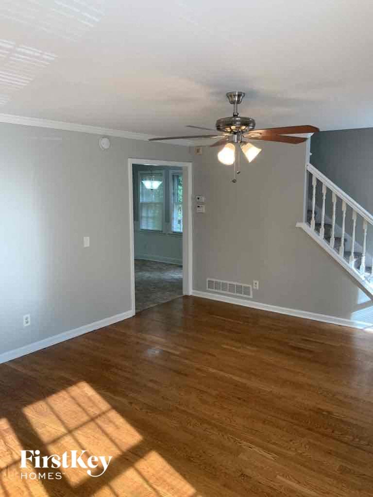 an empty living room with a ceiling fan