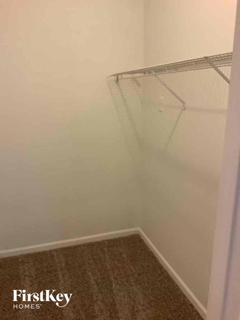 a walk in closet in a shared bathroom